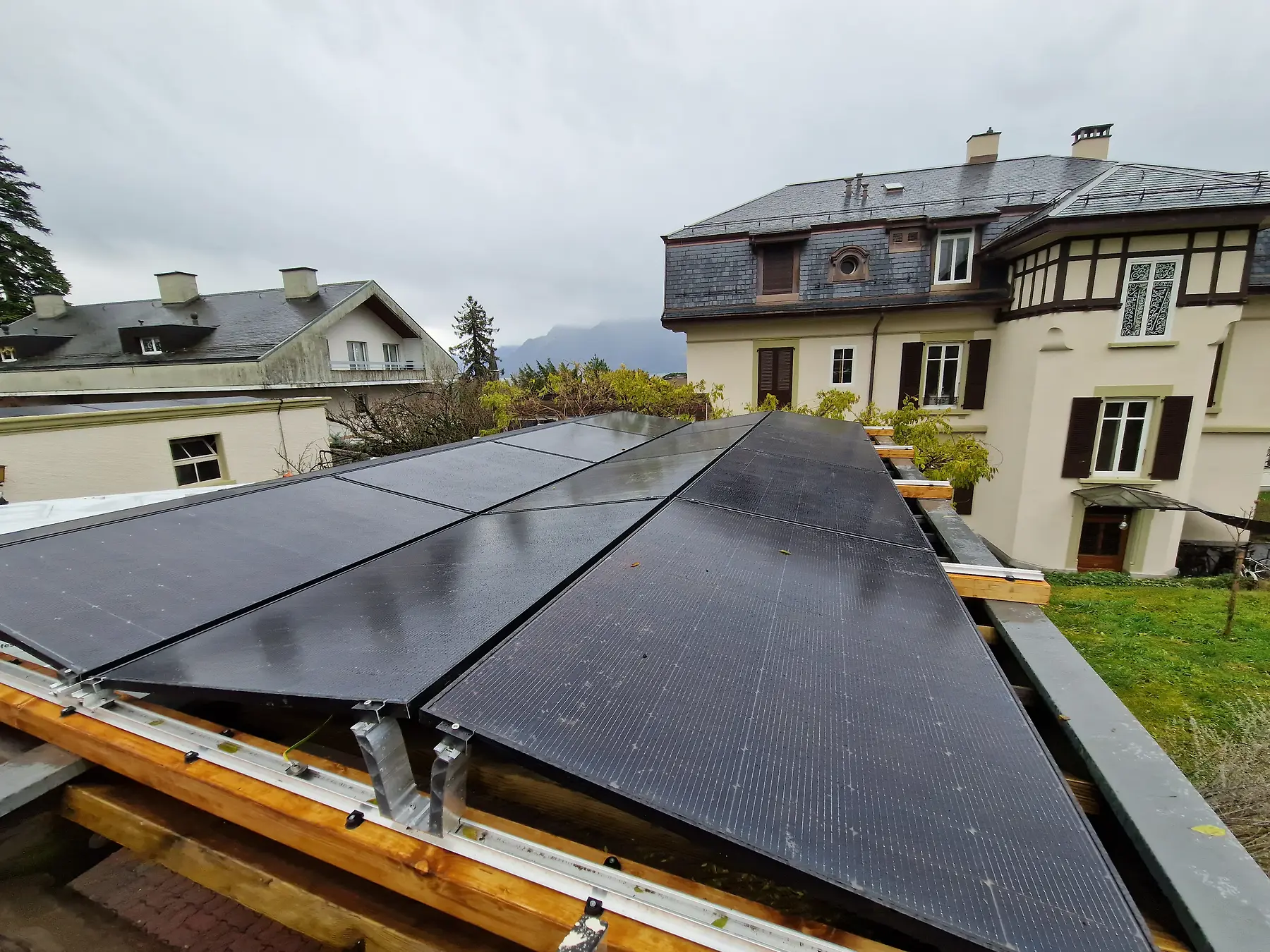 Panneaux photovoltaïques intégrés sur une structure en bois près d’un bâtiment existant