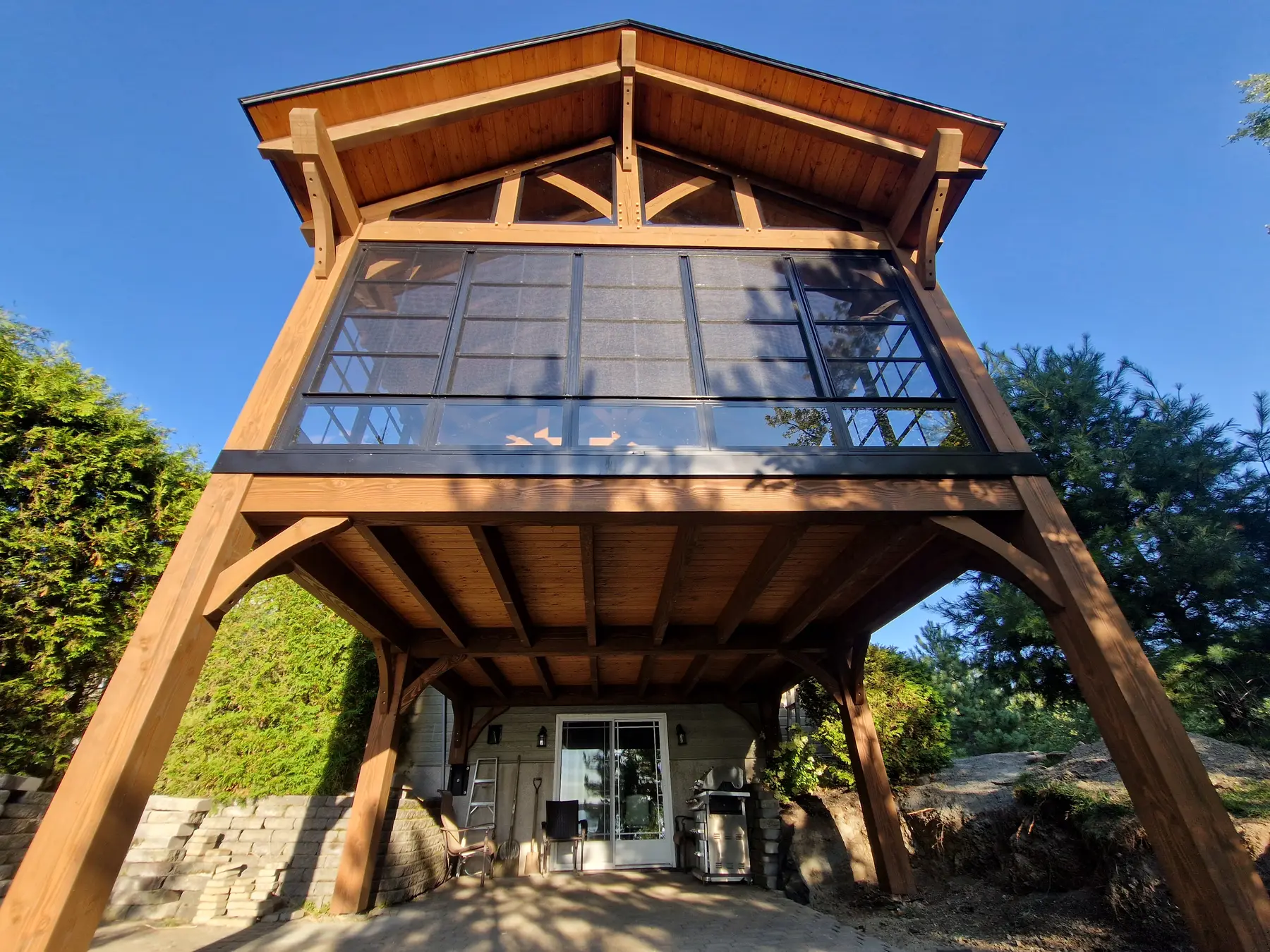 Pavillon en bois avec grande façade vitrée vu depuis le jardin